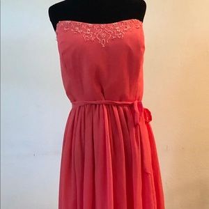 Coral pink colored strapless formal dress